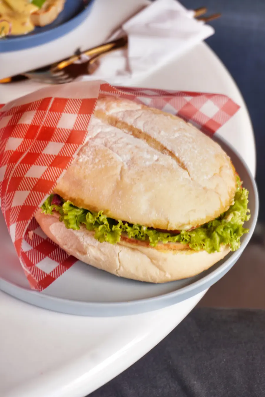 Sándwich con lechuga sobre servilleta de cuadros rojos